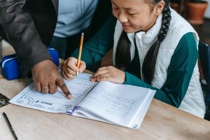 photo of a teacher helping a student